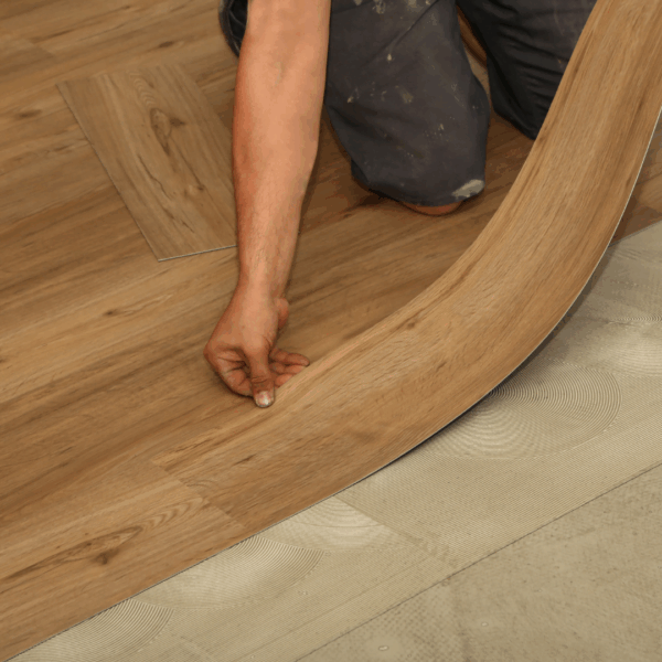 Close-up of a person laying curved wooden flooring